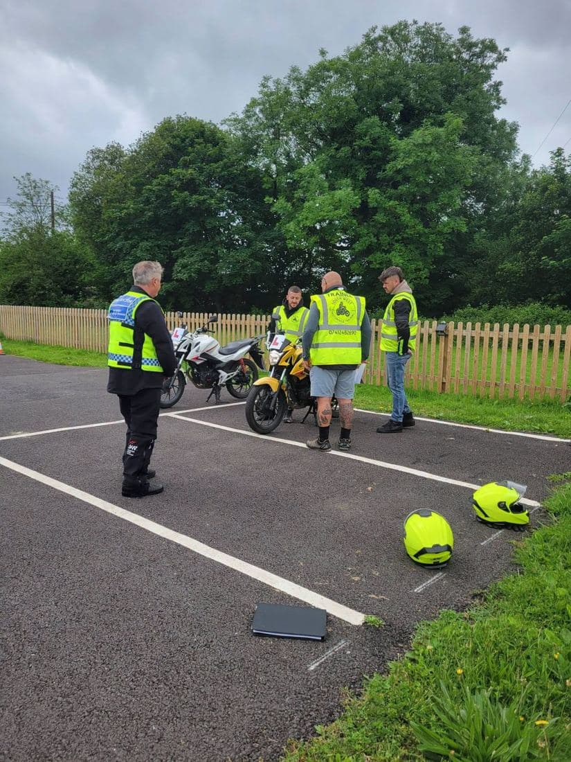 A South West Motorcycle Training instructor briefing riders beside L-plated training bikes on the marked manoeuvring pad at North Tawton A South West Motorcycle Training instructor briefing riders beside L-plated training bikes on the marked manoeuvring pad at North Tawton
